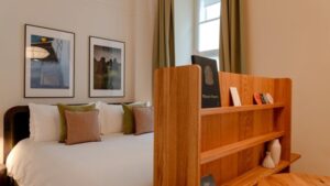 Bett mit Holzregal am Fußende