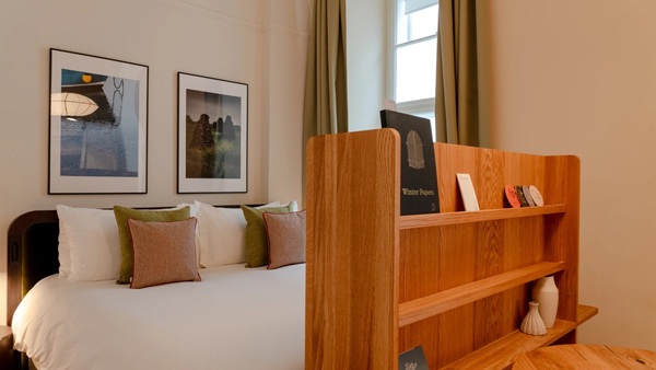 Bett mit Holzregal am Fußende