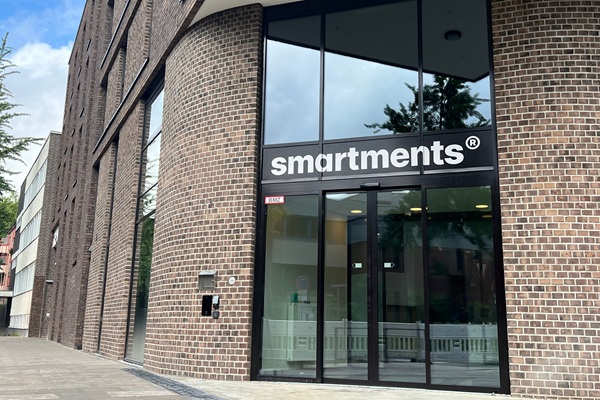Gläserner Eingang zu einem Gebäude von Smartments