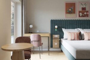 Zimmer im hellen Scandi-Style mit Bett, Schreibtisch und tisch