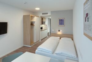 helles Zimmer mit minimalistischer Einrichtung und Doppelbett