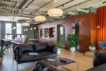 Ambiente einer Lobby mit schwarzem Sofa und rostbrauner Wand