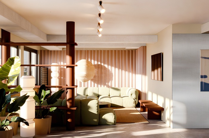 Gemütliches grünes Sofa hinter einem offenen Regal als Raumteiler