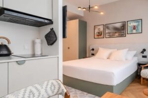 Blick in ein Apartment mit Doppelbett und kleiner Küchenzeile