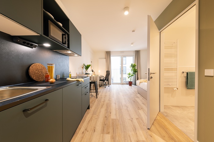 Apartment mit Küchenzeile, Schreibtisch und Bett